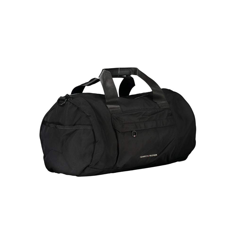 Handbag by Tommy Hilfiger for unisex in polyester black & print features a ornamental silhouette, showcasing a secure zipper, ample built-in-compartments, external-pockets & internal-pockets, and ornamental shoulder-strap, adjustable-strap & handle for a sophisticated look.