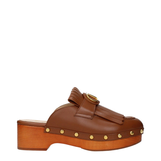 Clogs Slippers by Valentino Garavani for women in leather brown presents a effortless silhouette, showcasing the elegant Women's Leather Clogs Slippers design with its unique and sophisticated .